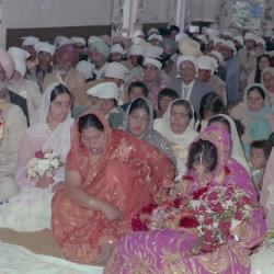 [Photo of Ajmer S. Sidhu, an unidentified woman and their wedding guests]