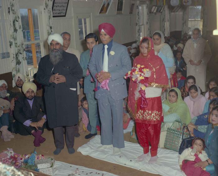 [Photo of Daljit Dhaliwal, an unidentified bride and wedding guests]