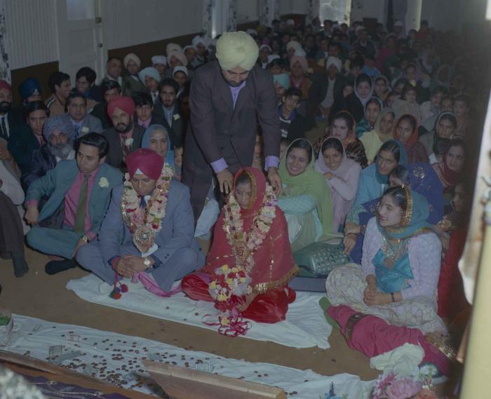 [Photo of Daljit Dhaliwal, an unidentified bride and wedding guests]