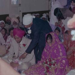 [Photo of Ajmer S. Sidhu, an unidentified woman and their wedding guests]
