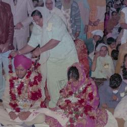 [Photo of Ajmer S. Sidhu, an unidentified woman and wedding guests on the Gurdwara steps]