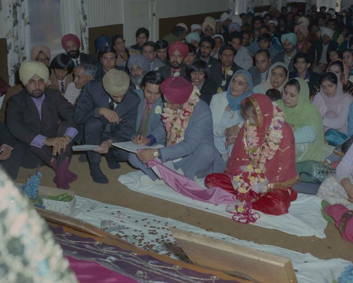 [Photo of Daljit Dhaliwal, an unidentified bride and wedding guests]