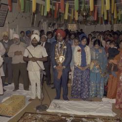 [Photo of Narwal Sidhu, an unidentified woman and their wedding guests]