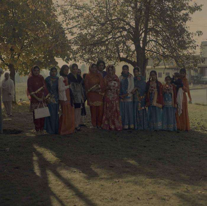 [Photo of Demindar Gill and a group of unidentified women]