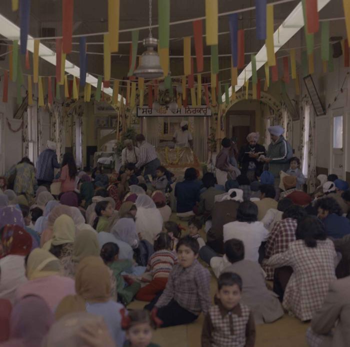[Photo of the wedding guests facing the front of the Gurdwara]
