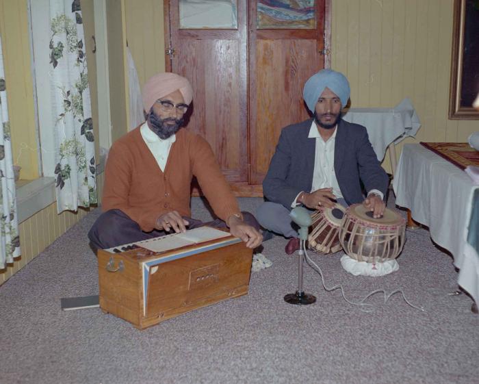 [Photo of two unidentified men playing instruments]