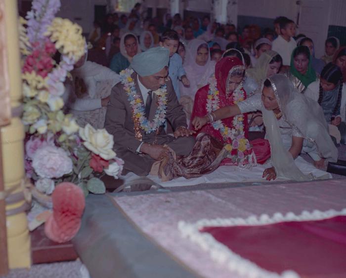 [Photo of an unidentified groom, an unidentified bride and wedding guests]