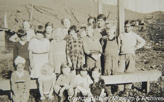 [Group of unidentified children standing in cutover land]