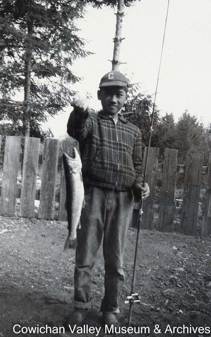 [Unidentified young man with a fishing rod and fish]