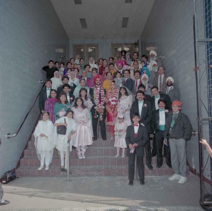 [Photo of Harjinder Gill, Wendy Grewal and the wedding guests posing on the Gurdwara steps]