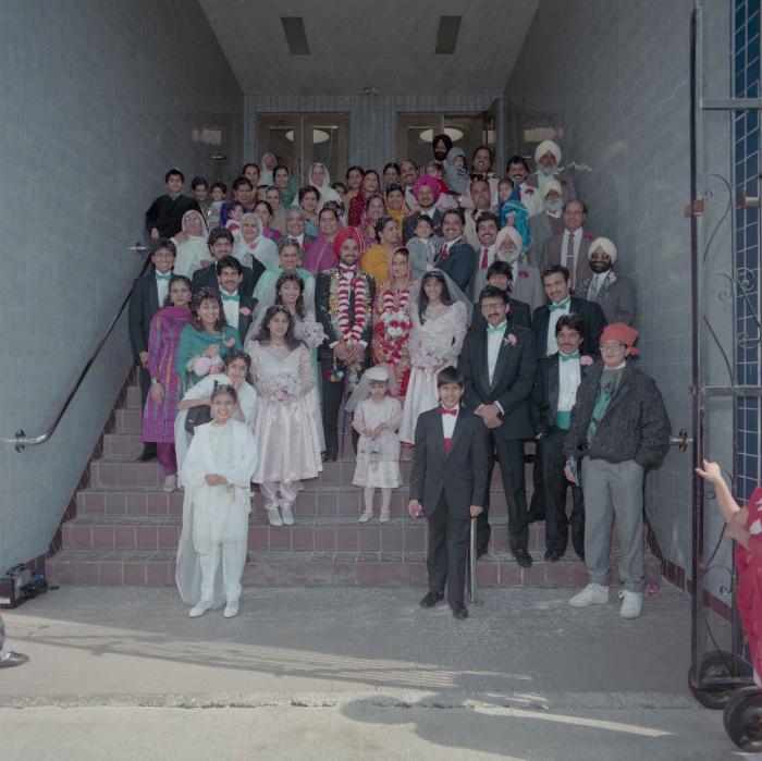 [Photo of Harjinder Gill, Wendy Grewal and the wedding guests posing on the Gurdwara steps]