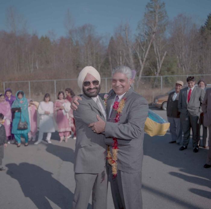 [Photo of two unidentified men embracing]