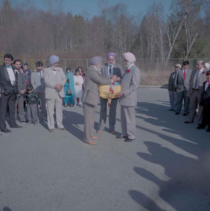 [Photo of unidentified group of weddings guests in the parking lot]