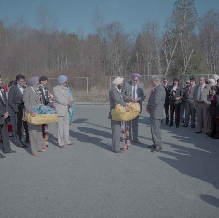 [Photo of unidentified group of weddings guests in the parking lot]