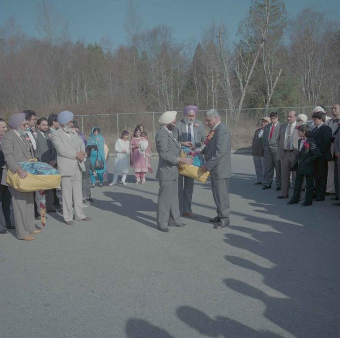 [Photo of unidentified group of weddings guests in the parking lot]