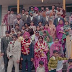 [Photo of Baljinder Gill, Gurcharah Dhaliwal and the wedding guests on the Gurdwara steps]