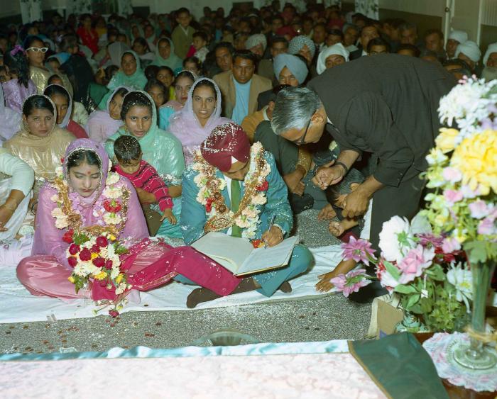[Group photo of Brant Dhaliwal and Gurwail Sidhu with wedding guests in Gurdwara]