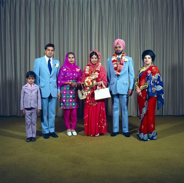 [Group photo of Braich and unidentified  bride with wedding guests]