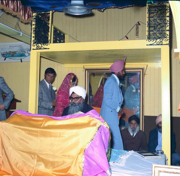 [Group photo of Braich and unidentified  bride involved in a sikh ritual]