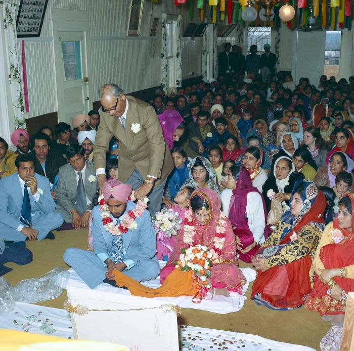 [Group photo of Braich and unidentified  bride with wedding guests]