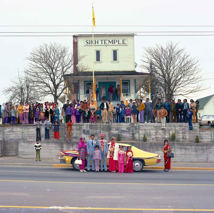 [Group photo of Braich and unidentified  bride with wedding guests outside Gur Sikh Temple]