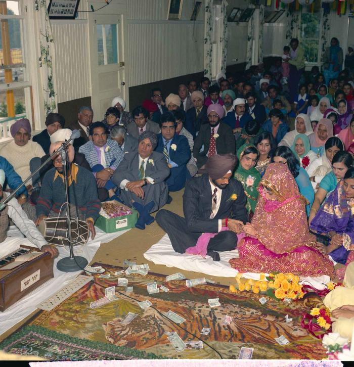 [Group photo of Balbir Khangura and Baljit Gill with wedding guests in ring ceremony]