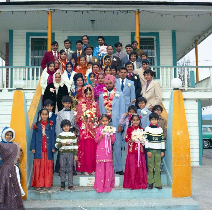 [Group photo of Braich and unidentified  bride with wedding guests]