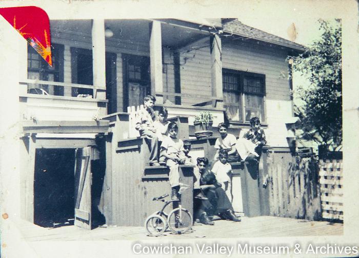 [Group of seven unidentified children and one unidentified man sitting on steps]