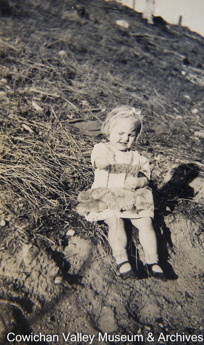 [Shirley Ross as a toddler sitting on a hill]