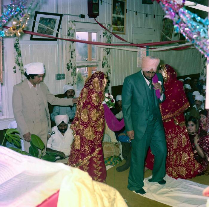 [Group photo of Inderjit Cheema and unidentified bride during marriage ritual]