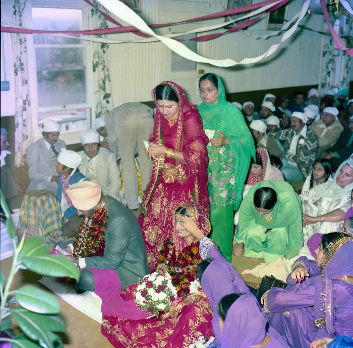 [Group photo of Inderjit Cheema and unidentified bride with wedding guests]