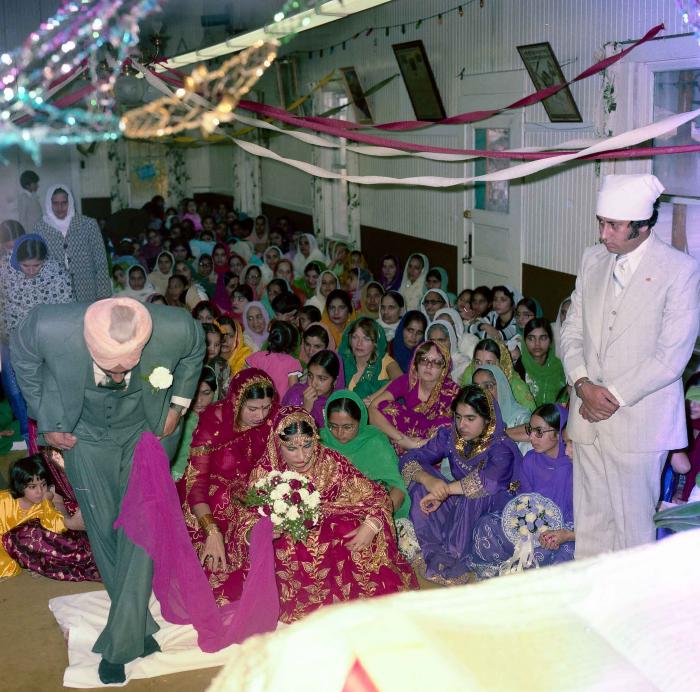 [Group photo of Inderjit Cheema and unidentified bride with wedding guests]