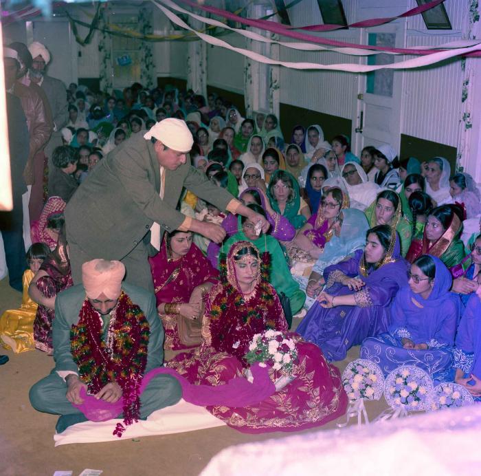 [Group photo of Inderjit Cheema and unidentified bride with wedding guests]