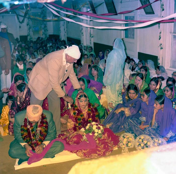 [Group photo of Inderjit Cheema and unidentified  bride with wedding guests]