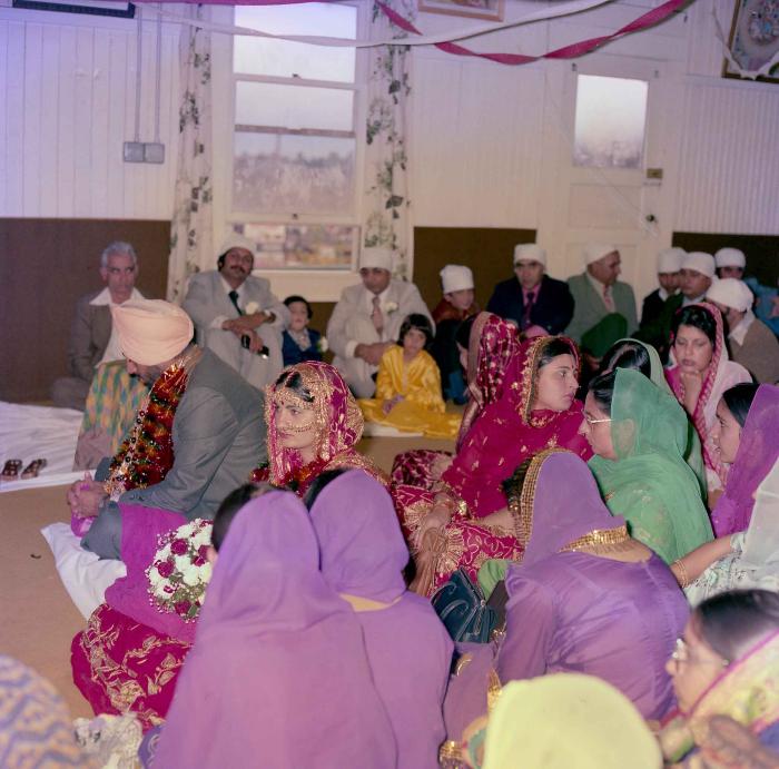 [Group photo of Inderjit Cheema and unidentified bride with wedding guests]