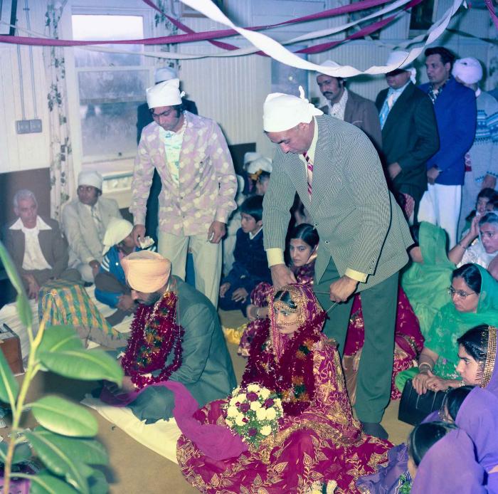 [Group photo of Inderjit Cheema and unidentified bride with wedding guests]