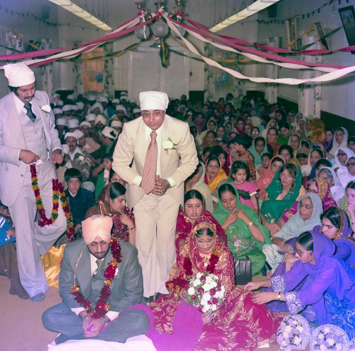 [Group photo of Inderjit Cheema and unidentified bride with wedding guests]