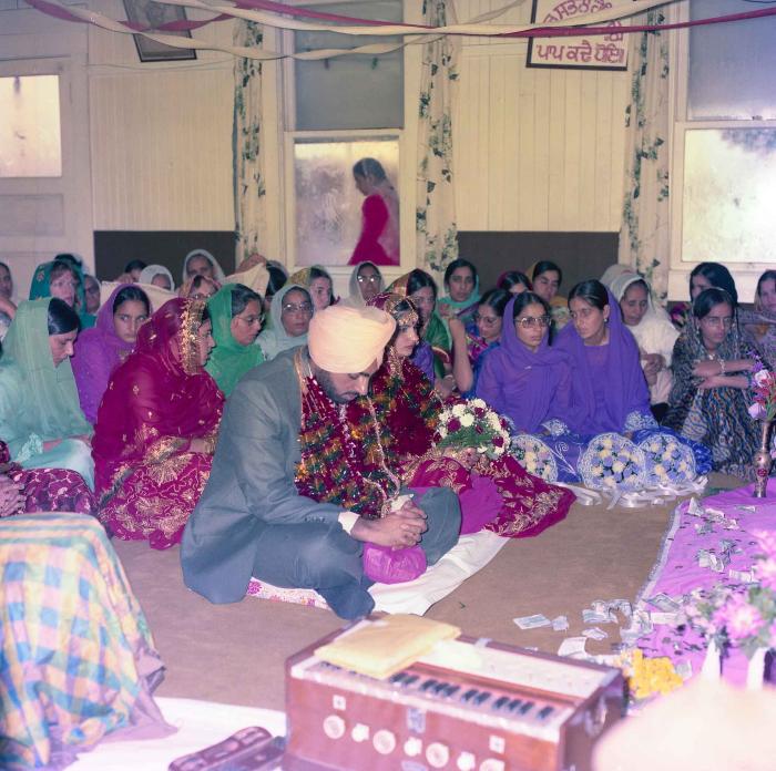 [Group photo of Inderjit Cheema and unidentified bride with wedding guests]