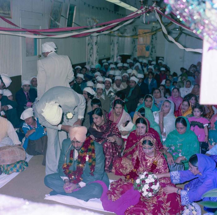 [Group photo of Inderjit Cheema and unidentified bride with wedding guests]