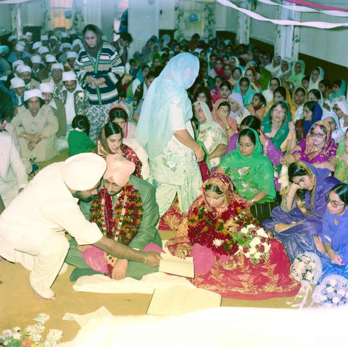 [Group photo of Inderjit Cheema and unidentified bride with wedding guests]