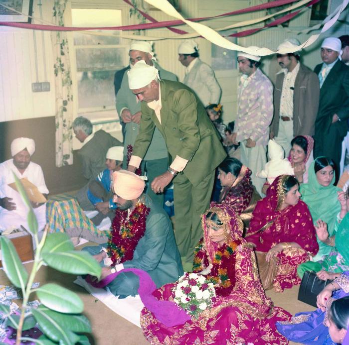 [Group photo of Inderjit Cheema and unidentified  bride with wedding guests]