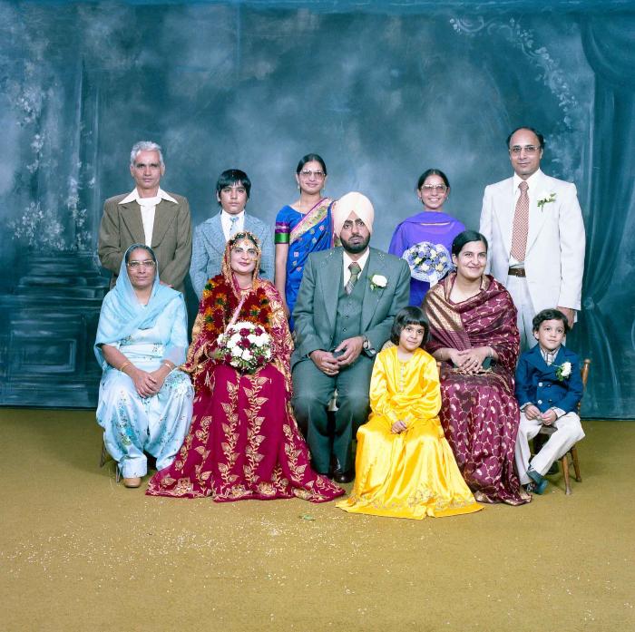 [Group photo of Inderjit Cheema and unidentified bride with wedding guests]