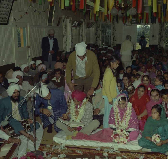[Group photo of Kehar S. Cheema and unidentified bride with wedding guests]