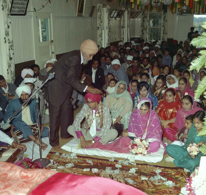 [Group photo of Kehar S. Cheema and unidentified bride with wedding guests]