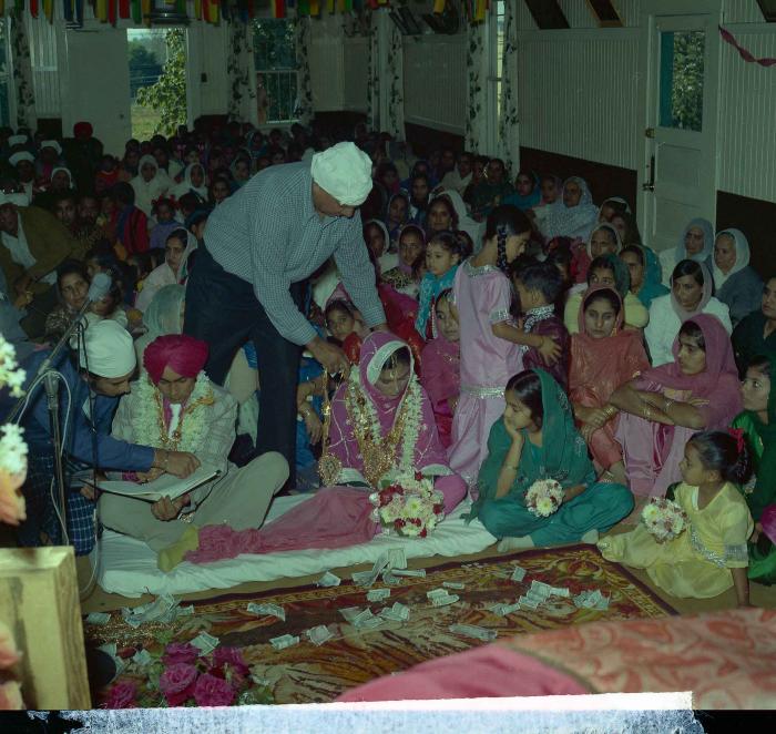 [Group photo of Kehar S. Cheema and unidentified bride with wedding guests]