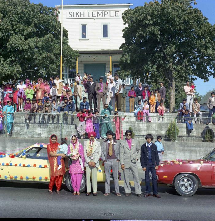[Group photo of Kehar S. Cheema and unidentified bride with wedding guests outside Gur Sikh Temple]