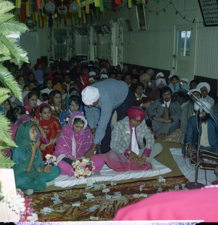 [Group photo of Kehar S. Cheema and unidentified bride with wedding guests]