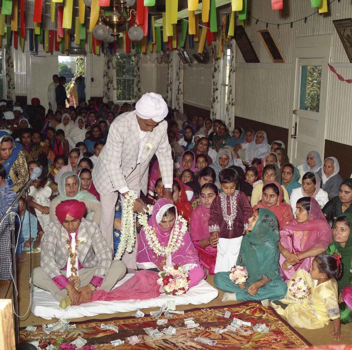 [Group photo of Kehar S. Cheema and unidentified bride with wedding guests]