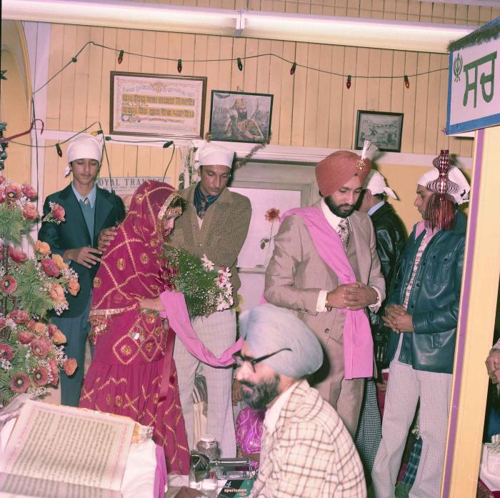 [Group photo of Jagpal Davinder and Manjit Sarowa with wedding guests during marriage ritual]