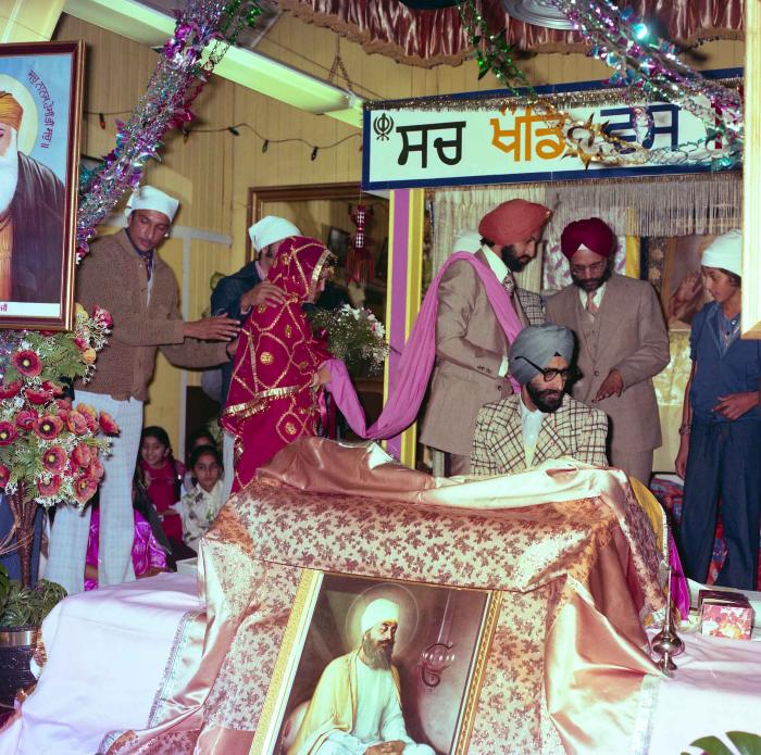 [Group photo of Jagpal Davinder and Manjit Sarowa with wedding guests during marriage ritual]
